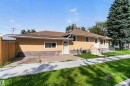 Single-story residence featuring a shingle roof, stucco exterior with stone-look wainscoting, and a concrete pathway - 9402 117 Avenue Nw, Edmonton, AB  - Outdoor 