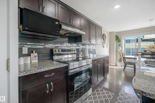 Dark wood-finish cabinetry with stainless steel hardware - 3359 13 Avenue Nw, Edmonton, AB 