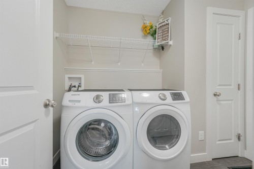 Laundry area with built-in wire shelving and light-colored wall paint - 3359 13 Avenue Nw, Edmonton, AB 