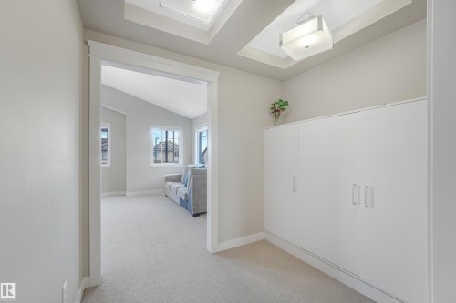 Recessed ceiling with an integrated light fixture, skylight, wall-to-wall carpeting, and built-in white cabinetry - 3359 13 Avenue Nw, Edmonton, AB 
