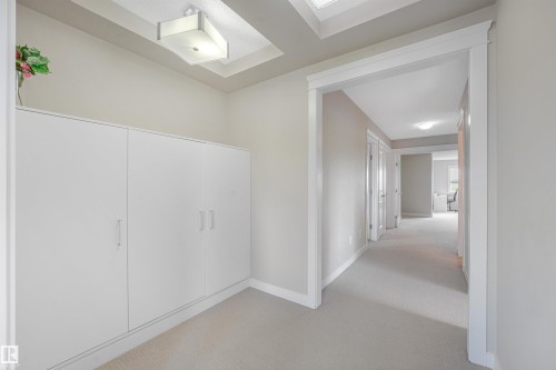 Recessed ceiling with an overhead light fixture, light gray walls, white built-in cabinetry, white trim, and light-colored carpet flooring - 3359 13 Avenue Nw, Edmonton, AB 