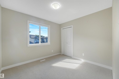 Neutral paint palette with light-colored carpeting, a double-paned window, and a flush-mount ceiling light - 3359 13 Avenue Nw, Edmonton, AB 