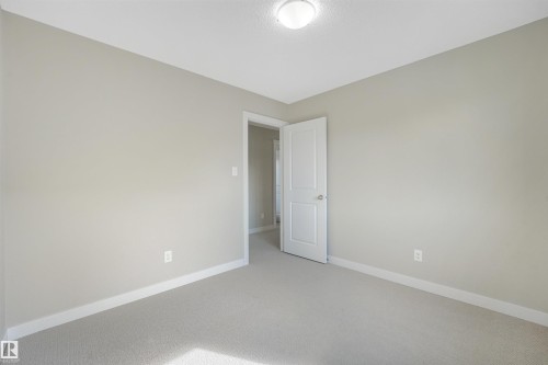 Light-colored carpeting, white trim, and a semi-flush mount ceiling fixture - 3359 13 Avenue Nw, Edmonton, AB 