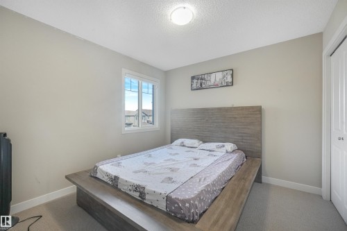 Light gray wall paint, carpet flooring, a single window with white trim, and a built-in closet with a white door - 3359 13 Avenue Nw, Edmonton, AB 