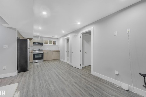 Modern kitchen with stainless steel appliances, light wood-finish cabinetry, and recessed lighting - 3359 13 Avenue Nw, Edmonton, AB 