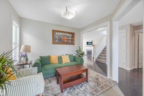 Recessed window providing natural light, overhead lighting fixture, wood-finish flooring, white trim work, and a stairway with white railings - 3359 13 Avenue Nw, Edmonton, AB 