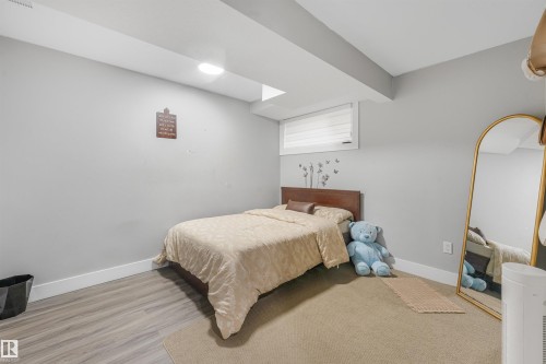 Wood-finish flooring, recessed lighting, and a window with horizontal blinds - 3359 13 Avenue Nw, Edmonton, AB 