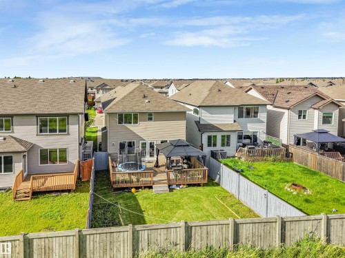 Expansive backyard featuring a manicured lawn, wood deck, and partial privacy fencing - 3359 13 Avenue Nw, Edmonton, AB 