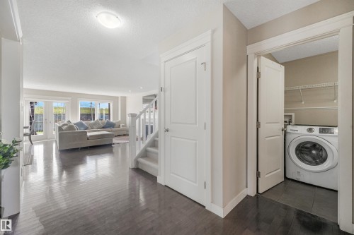Dark wood-finish flooring throughout the main level - 3359 13 Avenue Nw, Edmonton, AB 