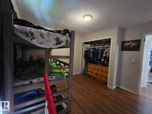 Wood-finish flooring, built-in open closet storage, flush-mount ceiling light fixture, and light-toned wall paint - 3511 28 Avenue Nw, Edmonton, AB - Indoor