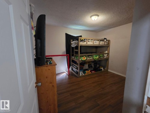 Wood-finish flooring with white baseboards, and a flush mount ceiling light - 3511 28 Avenue Nw, Edmonton, AB - Indoor Photo Showing Other Room