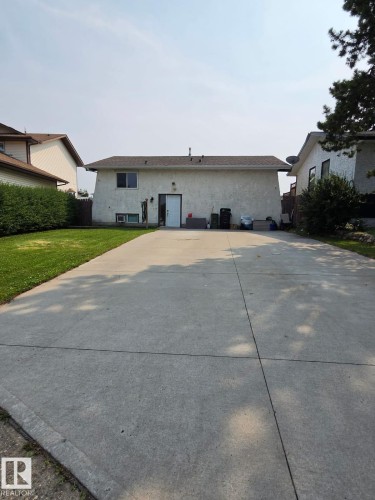 Expansive concrete driveway leading to a stucco exterior with a durable shingle roof - 3511 28 Avenue Nw, Edmonton, AB - Outdoor