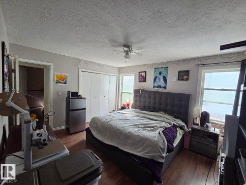 Wood-finish flooring, ceiling fan, and white trim accents - 3511 28 Avenue Nw, Edmonton, AB - Indoor Photo Showing Bedroom