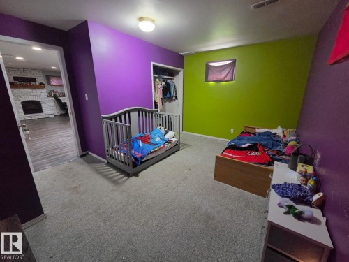 Carpeted room with a ceiling-mounted light fixture and a closet with a bi-fold door - 3511 28 Avenue Nw, Edmonton, AB - Indoor Photo Showing Bedroom