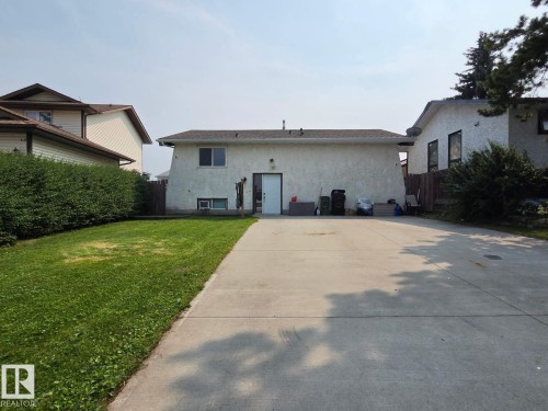 Expansive concrete driveway, stucco exterior, and a manicured lawn - 3511 28 Avenue Nw, Edmonton, AB - Outdoor