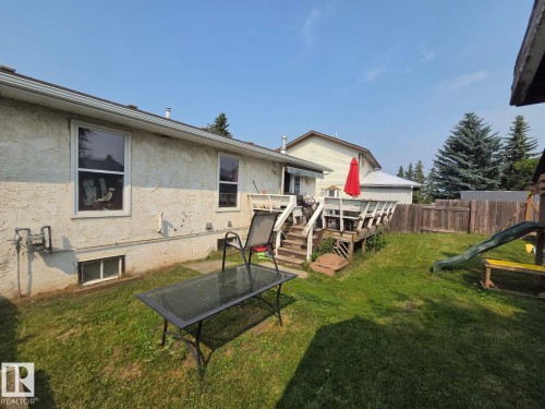 Expansive backyard featuring a wood deck, wood privacy fencing, and mature trees - 3511 28 Avenue Nw, Edmonton, AB - Outdoor With Deck Patio Veranda