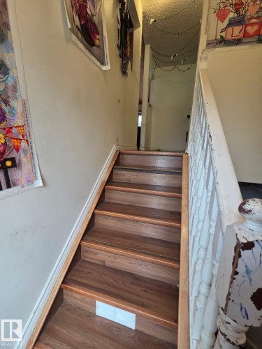 Staircase featuring wood-finish treads and risers with a painted handrail - 3511 28 Avenue Nw, Edmonton, AB - Indoor Photo Showing Other Room