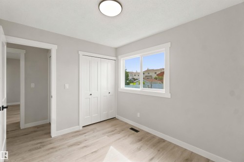 Wood-finish flooring, white trim, bi-fold closet doors, white window frame, and recessed lighting - 4129 134A Avenue Nw, Edmonton, AB - Indoor Photo Showing Other Room