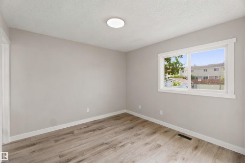 Neutral wall paint, wood-finish flooring, white trim, and a ceiling-mounted light fixture - 4129 134A Avenue Nw, Edmonton, AB - Indoor Photo Showing Other Room