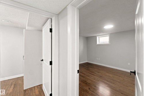Wood-finish flooring, white trim, recessed lighting, and a window provide natural light - 4129 134A Avenue Nw, Edmonton, AB - Indoor