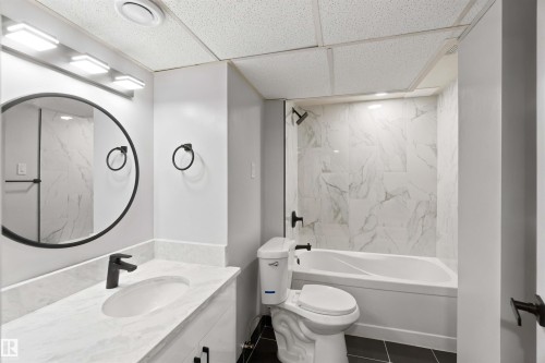 White vanity with a single basin and white countertop - 4129 134A Avenue Nw, Edmonton, AB - Indoor Photo Showing Bathroom
