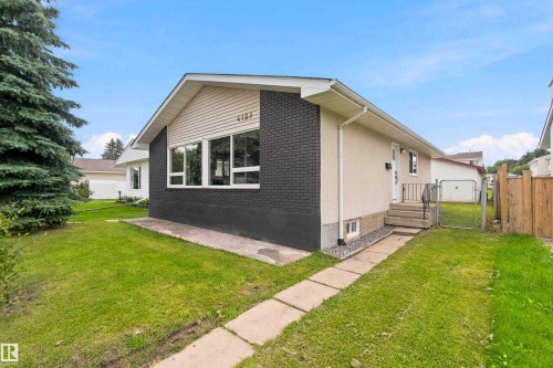 Siding exterior with black brick accents, white trim, and a concrete pathway - 4129 134A Avenue Nw, Edmonton, AB - Outdoor