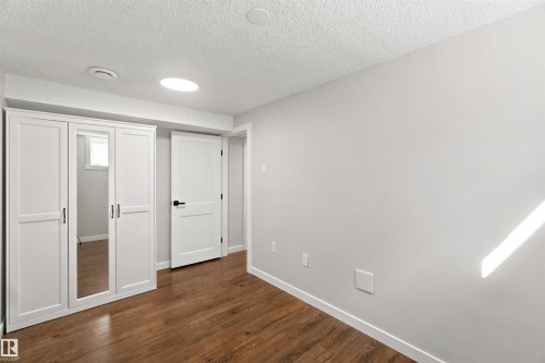 Wood-finish flooring with white trim and light gray walls - 4129 134A Avenue Nw, Edmonton, AB - Indoor Photo Showing Other Room