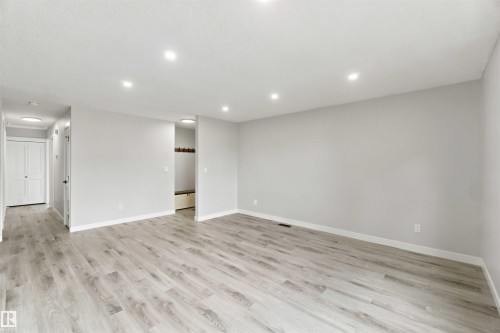 Spacious room with wood-finish flooring, recessed lighting, and light-toned walls - 4129 134A Avenue Nw, Edmonton, AB - Indoor