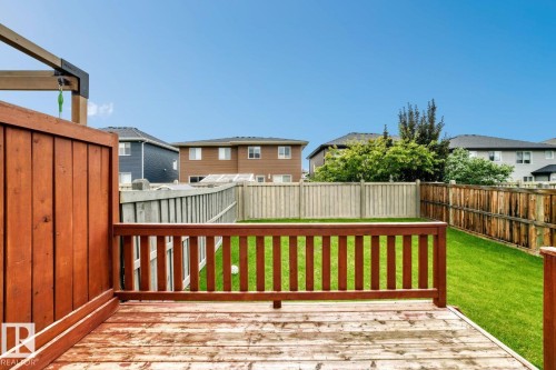 Deck with a wood railing and board fence overlooking a grass lawn - 1112 176 Street Sw, Edmonton, AB - Outdoor With Exterior