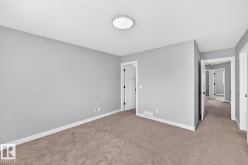 Neutral wall paint, textured ceiling, flush mount ceiling light, and plush carpet flooring - 1112 176 Street Sw, Edmonton, AB - Indoor Photo Showing Other Room