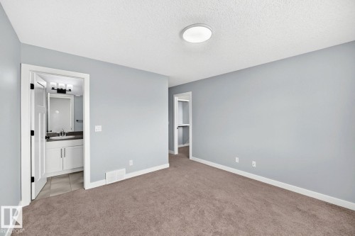 Light gray wall paint, textured ceiling, flush mount ceiling light, light brown carpeting, white trim - 1112 176 Street Sw, Edmonton, AB - Indoor Photo Showing Other Room