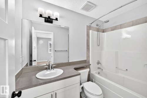 Bathroom featuring a single vanity with a white basin sink, polished chrome faucet, and gray countertop - 1112 176 Street Sw, Edmonton, AB - Indoor Photo Showing Bathroom