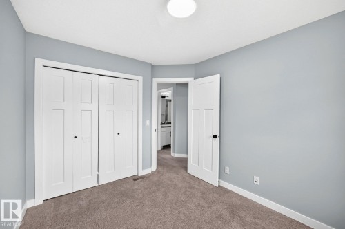 Neutral gray wall finish, white trim, recessed ceiling light, paneled interior doors, and carpet flooring - 1112 176 Street Sw, Edmonton, AB - Indoor
