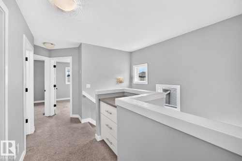 Hallway with gray carpeting, white trim, and light gray walls - 1112 176 Street Sw, Edmonton, AB - Indoor