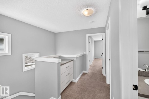 Upper-level hallway featuring neutral gray walls, carpet flooring, and white trim - 1112 176 Street Sw, Edmonton, AB - Indoor Photo Showing Other Room