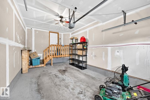 Garage with concrete flooring, exposed wall studs, and a ceiling fan - 1112 176 Street Sw, Edmonton, AB - Indoor Photo Showing Garage