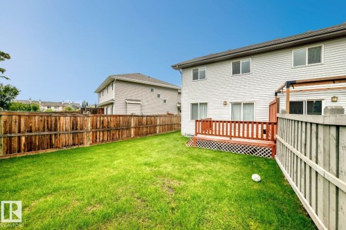 Expansive backyard featuring a manicured lawn, full wood fencing, and a wooden deck - 1112 176 Street Sw, Edmonton, AB - Outdoor With Exterior