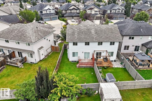 Expansive green lawn, wood-finish decking, and light-toned siding - 1112 176 Street Sw, Edmonton, AB - Outdoor