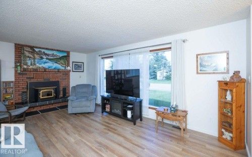 Brick fireplace with a wood-burning insert - 10729 108A Avenue, Westlock, AB - Indoor Photo Showing Living Room With Fireplace