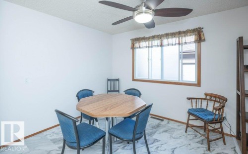 White walls, ceiling fan with integrated lighting, wood-trim window, and light-toned flooring - 10729 108A Avenue, Westlock, AB - Indoor Photo Showing Dining Room