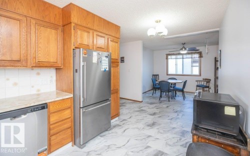 Wood-finish cabinetry with stainless steel appliances - 10729 108A Avenue, Westlock, AB - Indoor Photo Showing Kitchen