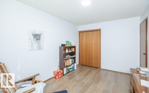 Wood-finish flooring with white walls and a textured ceiling - 10729 108A Avenue, Westlock, AB - Indoor