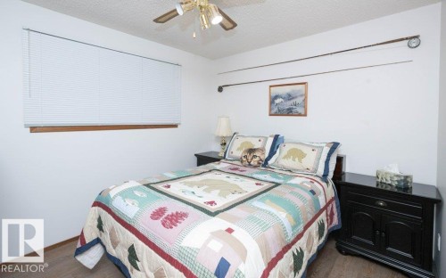Window with blinds and wood-finish trim - 10729 108A Avenue, Westlock, AB - Indoor Photo Showing Bedroom