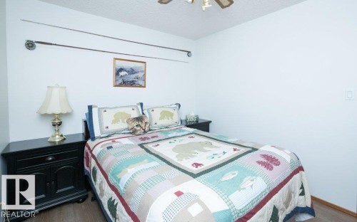 Wood-finish flooring with white walls and a ceiling fan - 10729 108A Avenue, Westlock, AB - Indoor Photo Showing Bedroom