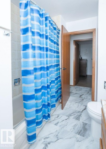 White bathtub with tile surround - 10729 108A Avenue, Westlock, AB - Indoor Photo Showing Bathroom