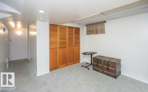 Recessed lighting, wood louvered bifold closet doors, and light gray carpeting - 10729 108A Avenue, Westlock, AB - Indoor Photo Showing Other Room