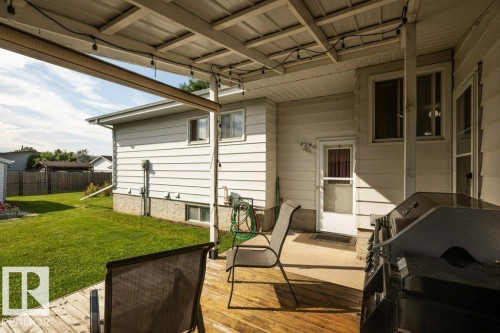 Wood-finish deck with a metal roof patio cover, featuring string lighting and an exterior mounted heater - 10729 108A Avenue, Westlock, AB - Outdoor With Deck Patio Veranda With Exterior