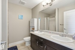 Dual vanity with integrated sinks, dark wood-finish cabinetry, and a full-width mirror - 