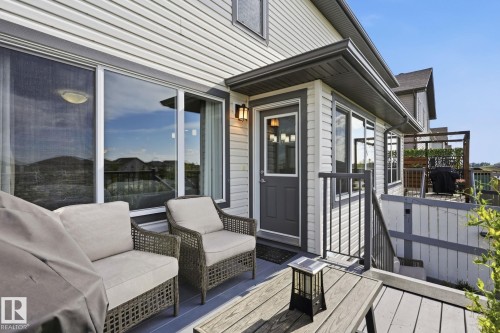Exterior siding with a windowed entryway, deck with composite decking, and metal railing - 944 Morris Way, Leduc, AB - Outdoor With Deck Patio Veranda With Exterior
