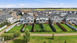 Expansive residential community featuring detached homes with backyards, established fencing, and a paved walking path - 